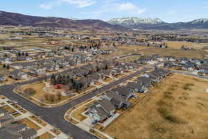 Aerial view of property and surrounding area featuring nearby suburban area and a mountain backdrop