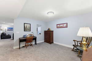 Office area featuring light colored carpet and baseboards