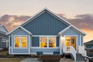 Rear view of property with board and batten siding, a patio area, and an outdoor hangout area