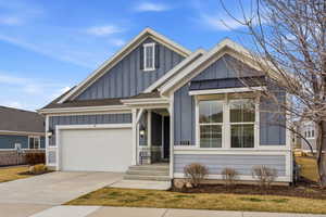 Craftsman house with board and batten siding, driveway, and a shingled roof