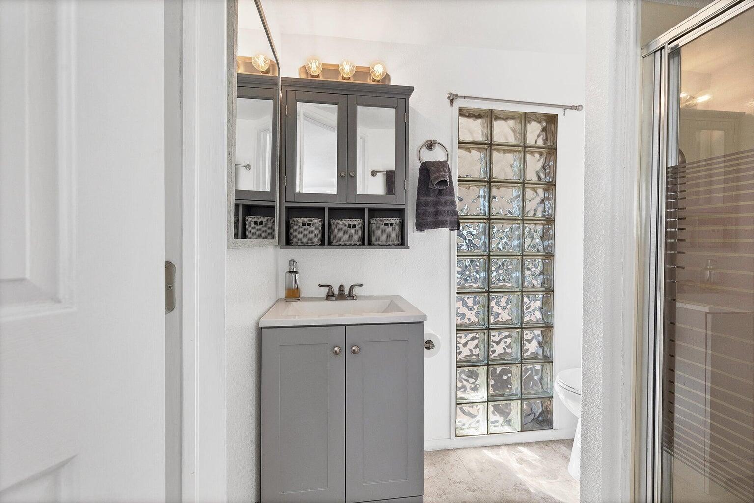 Bathroom vanity with a gray cabinet base and white countertop