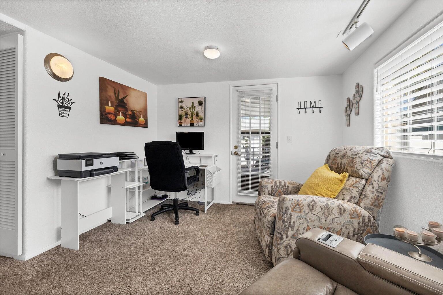 Carpeted interior room featuring a white ceiling, white walls, and track lighting