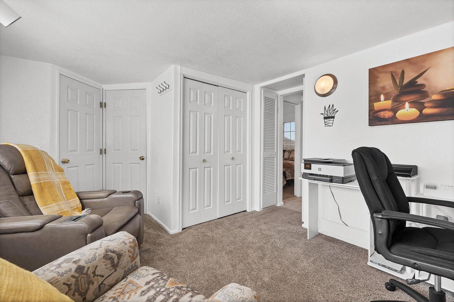 Carpeted room featuring multiple panel doors, a built-in wall sconce, and white painted trim