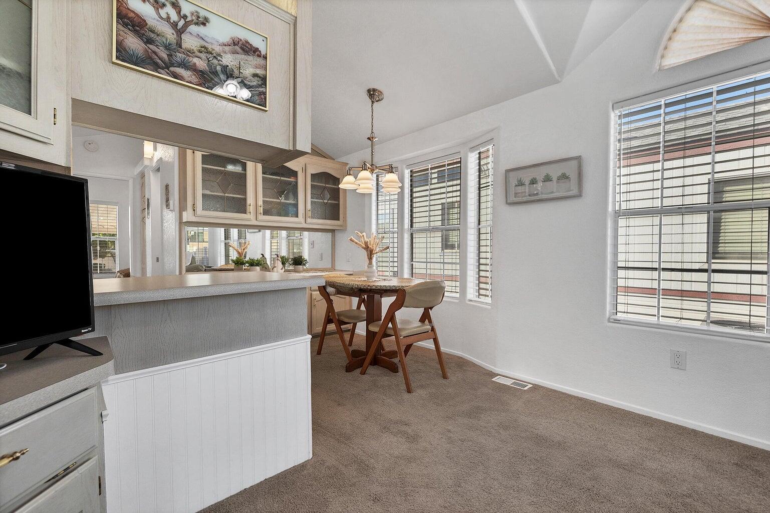 Dining area featuring a vaulted ceiling and carpet flooring