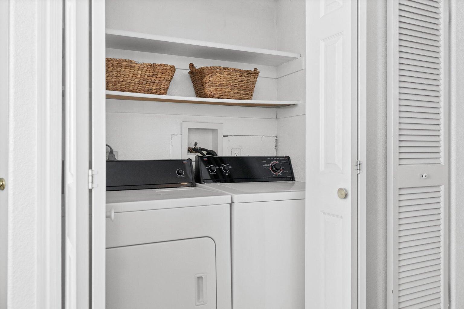 Dedicated laundry closet with white panel doors and louvered bifold doors