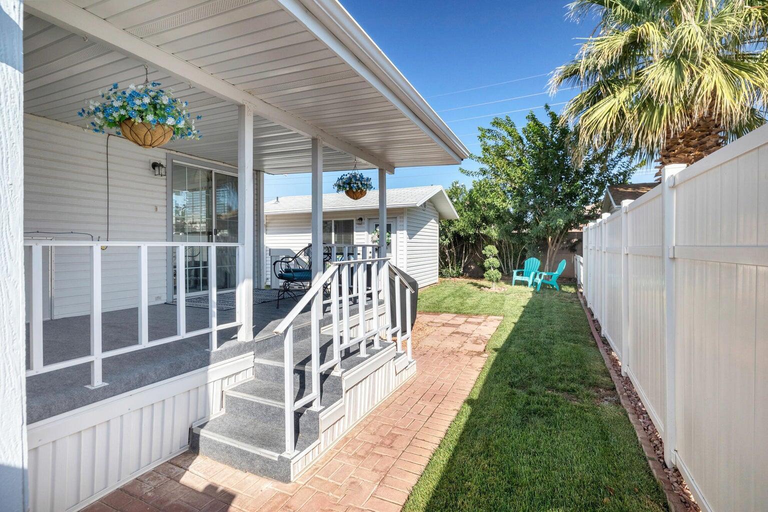 Covered porch with white railings and carpeted steps