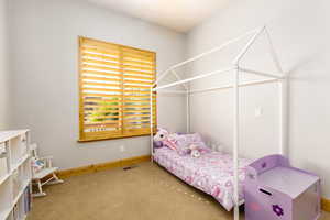 Bedroom featuring carpet and baseboards