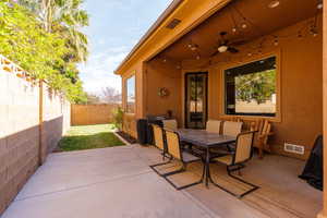 Fenced backyard featuring a patio area, outdoor dining space, a ceiling fan, and grilling area