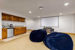 Cinema room with light carpet, recessed lighting, and wet bar