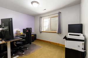 Home office featuring light colored carpet and baseboards