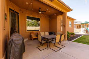 View of patio with ceiling fan and outdoor dining area