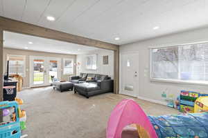 Living area featuring light carpet, french doors, recessed lighting, and beam ceiling