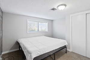 Bedroom with carpet flooring and a textured ceiling