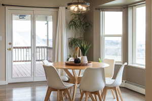 Dining room with light wood-style flooring, a baseboard heating unit, and a chandelier
