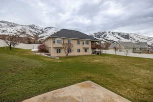 Back of property with a mountain view, a fenced backyard, and a balcony