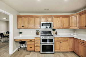 Kitchen featuring stainless steel appliances, light wood-style floors, recessed lighting, and wood finish cabinetry