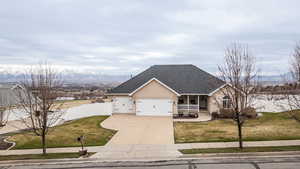 View of front of home with a porch, roof with shingles, stucco siding, a garage, and concrete driveway