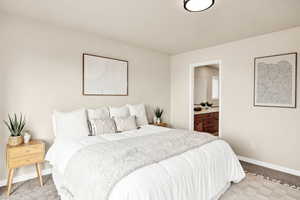 Bedroom featuring connected bathroom and light colored carpet