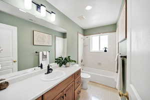 Bathroom featuring vanity, bathing tub / shower combination, and light floors