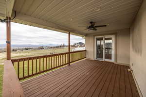 Deck featuring a ceiling fan, a yard, and a mountain view