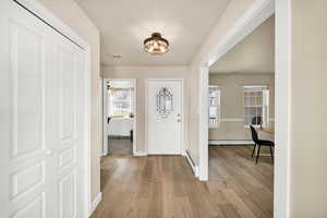 Foyer entrance with light wood-style floors and baseboard heating