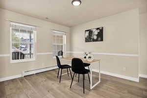 Office area with a baseboard radiator and light wood-type flooring