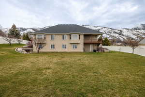Rear view of property featuring a mountain view, a fenced backyard, a patio area, a shingled roof, and a balcony