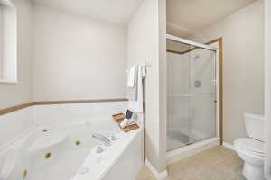 Full bath with a shower stall and a jetted tub