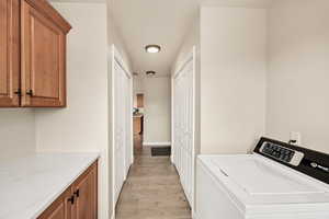 Laundry room featuring washer / dryer and light wood-type flooring