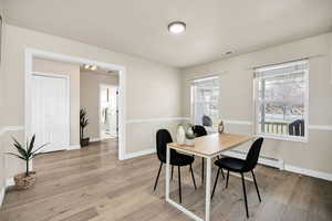 Dining area featuring light wood-type flooring and baseboard heating