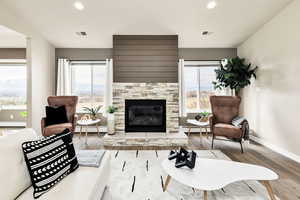 Living area featuring recessed lighting, wood finished floors, a fireplace, and baseboard heating