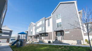 Rear view of house featuring stucco siding, a lawn, and brick siding