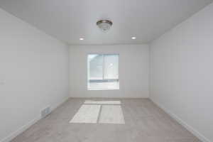 Spare room with light colored carpet and recessed lighting