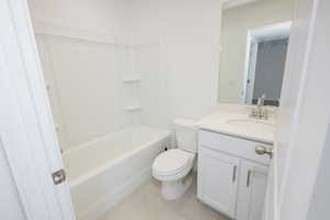 Full bath featuring vanity, shower / bath combination, and light tile patterned floors