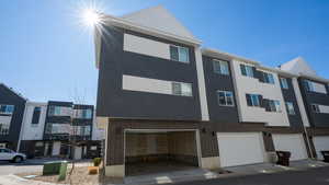 View of front of house featuring brick siding, a garage, and stucco siding