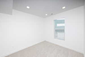 Spare room with light carpet and recessed lighting