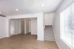 Stairs featuring wood finished floors and recessed lighting