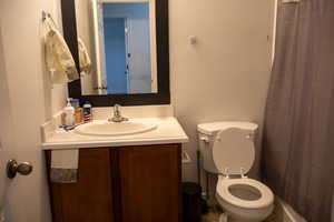 Bathroom with a textured wall, vanity, and a shower with curtain
