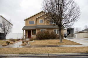 View of front of property featuring a porch, stucco siding, a detached carport, roof with shingles, and concrete driveway