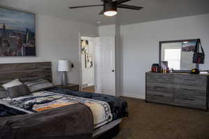 Bedroom featuring dark carpet and a ceiling fan