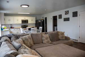 Living room featuring dark wood finished floors and washer / dryer
