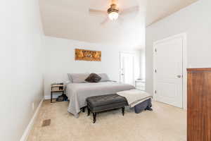Bedroom with light carpet, vaulted ceiling, and a ceiling fan