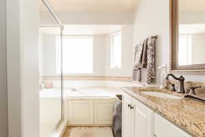 Full bathroom featuring vanity, a bath, and a shower