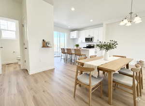 Dining area with light wood-style floors and a chandelier