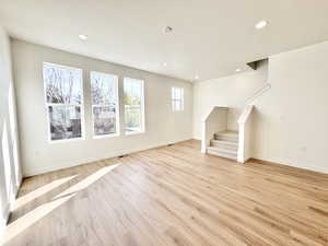 Unfurnished living room featuring light wood-type flooring, recessed lighting, and a textured ceiling