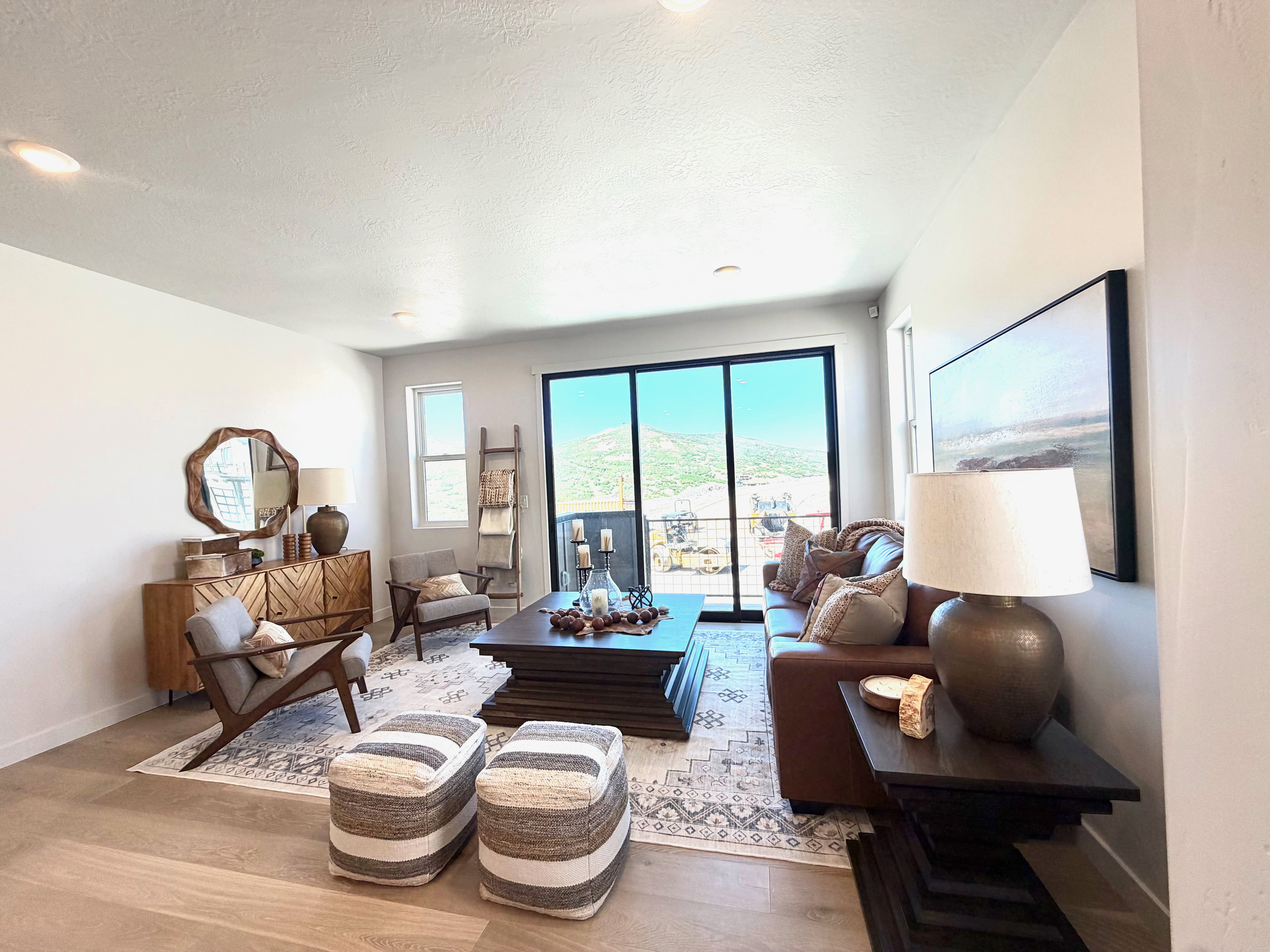 Living room featuring large sliding glass doors, light wood-finish flooring, recessed lighting, a rectangular window, and a decorative area rug