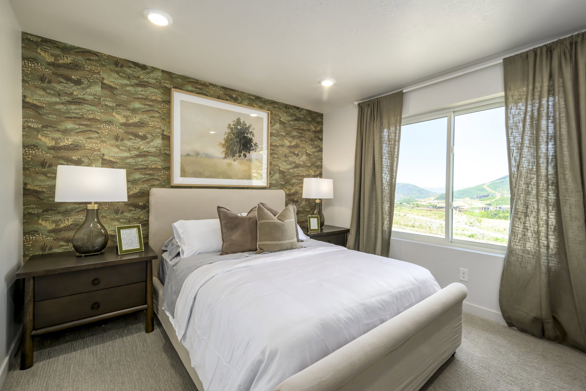 Bedroom featuring recessed lighting, a patterned accent wall, a window with exterior mountain scenery, and carpet flooring
