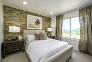 Bedroom featuring recessed lighting, a patterned accent wall, a window with exterior mountain scenery, and carpet flooring