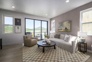 Living area featuring a full-light glass door, multiple windows, recessed lighting, and wood-finish flooring