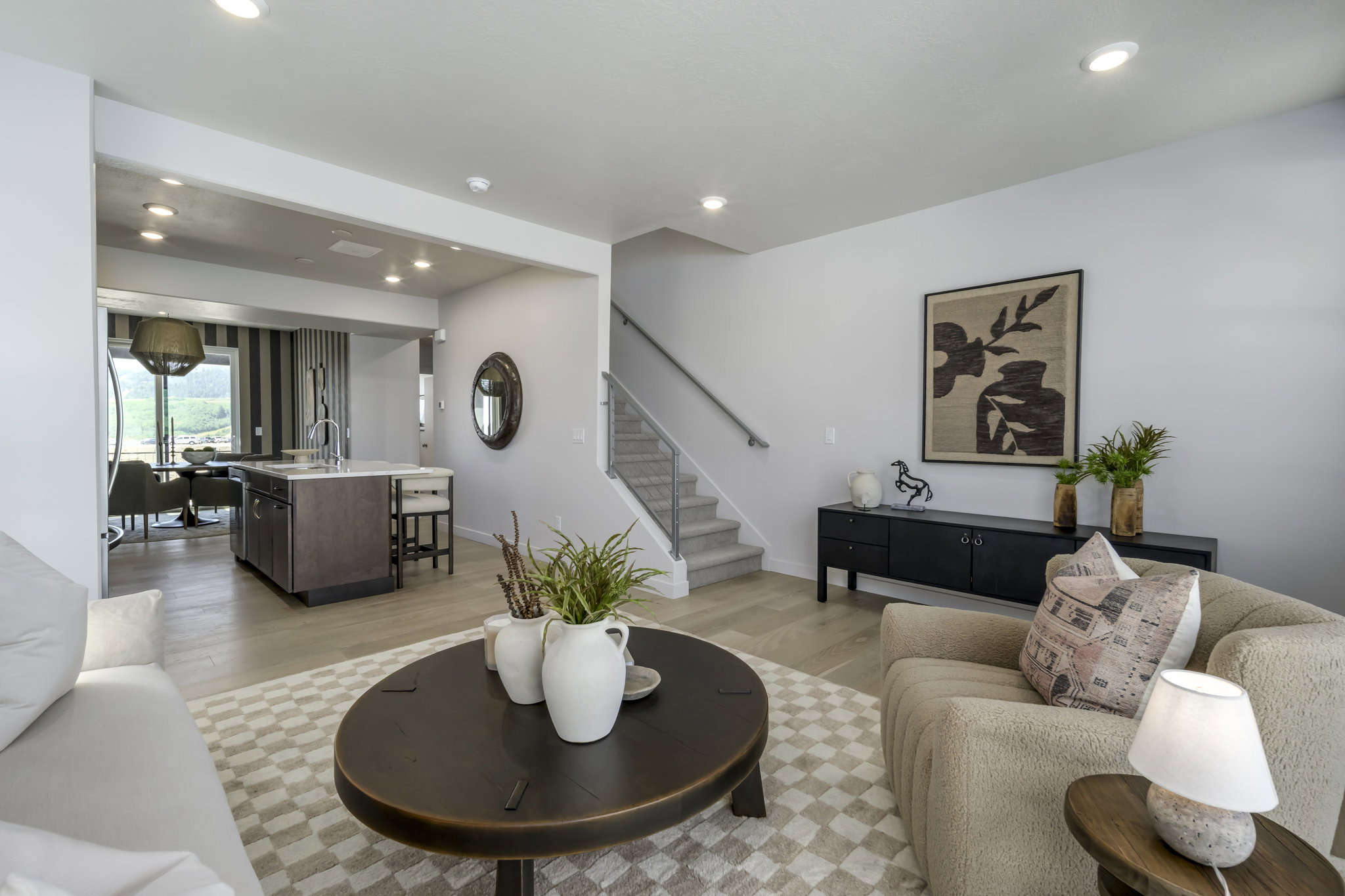 Open-concept living area featuring light wood-finish flooring, recessed lighting, and a kitchen island with seating